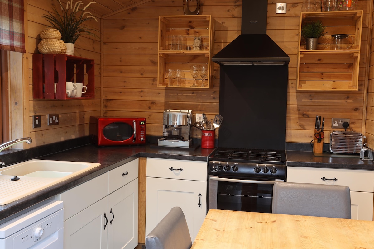 Kitchen with gas range, espresso machine and open crate shelving