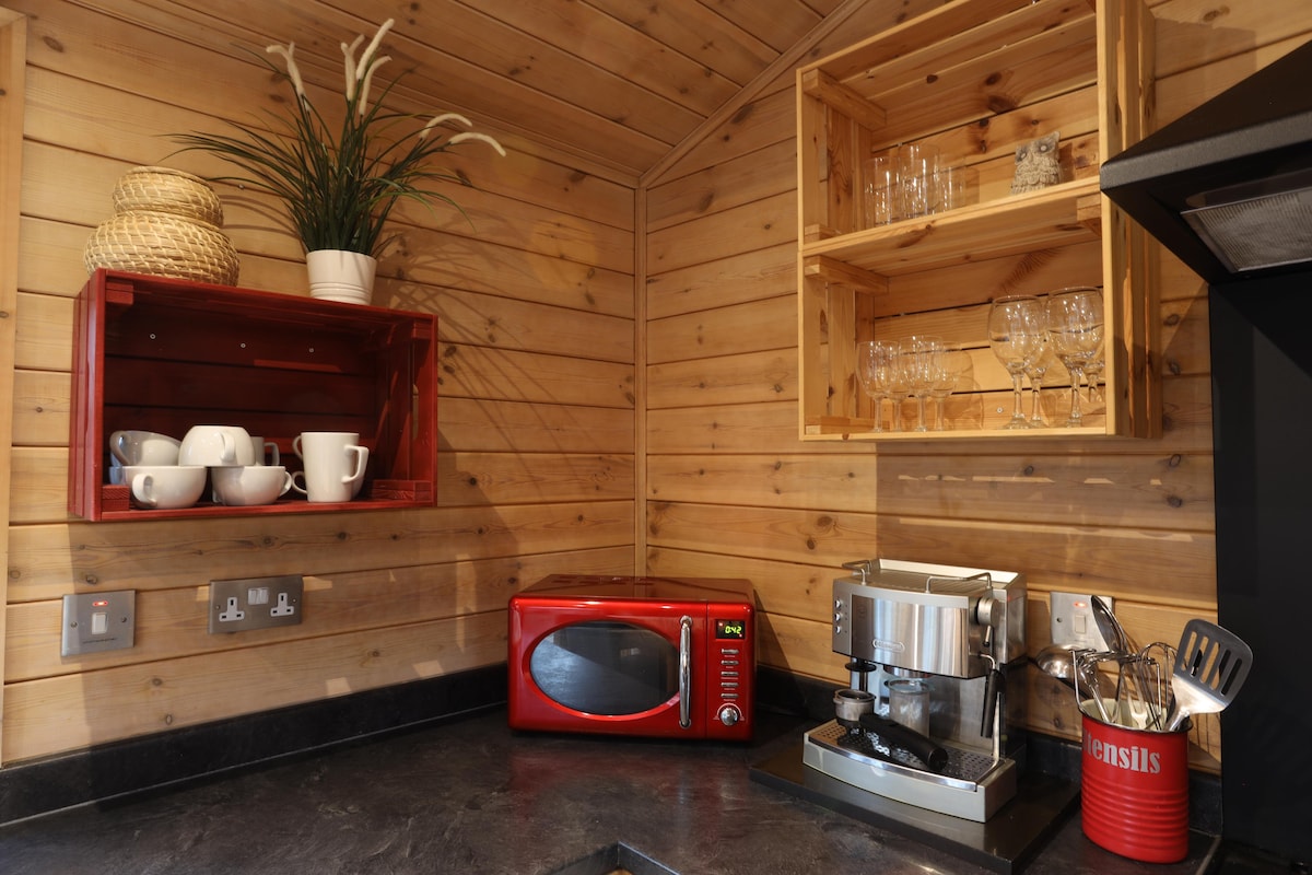 Kitchen counter with red microwave, espresso machine and open crate shelving