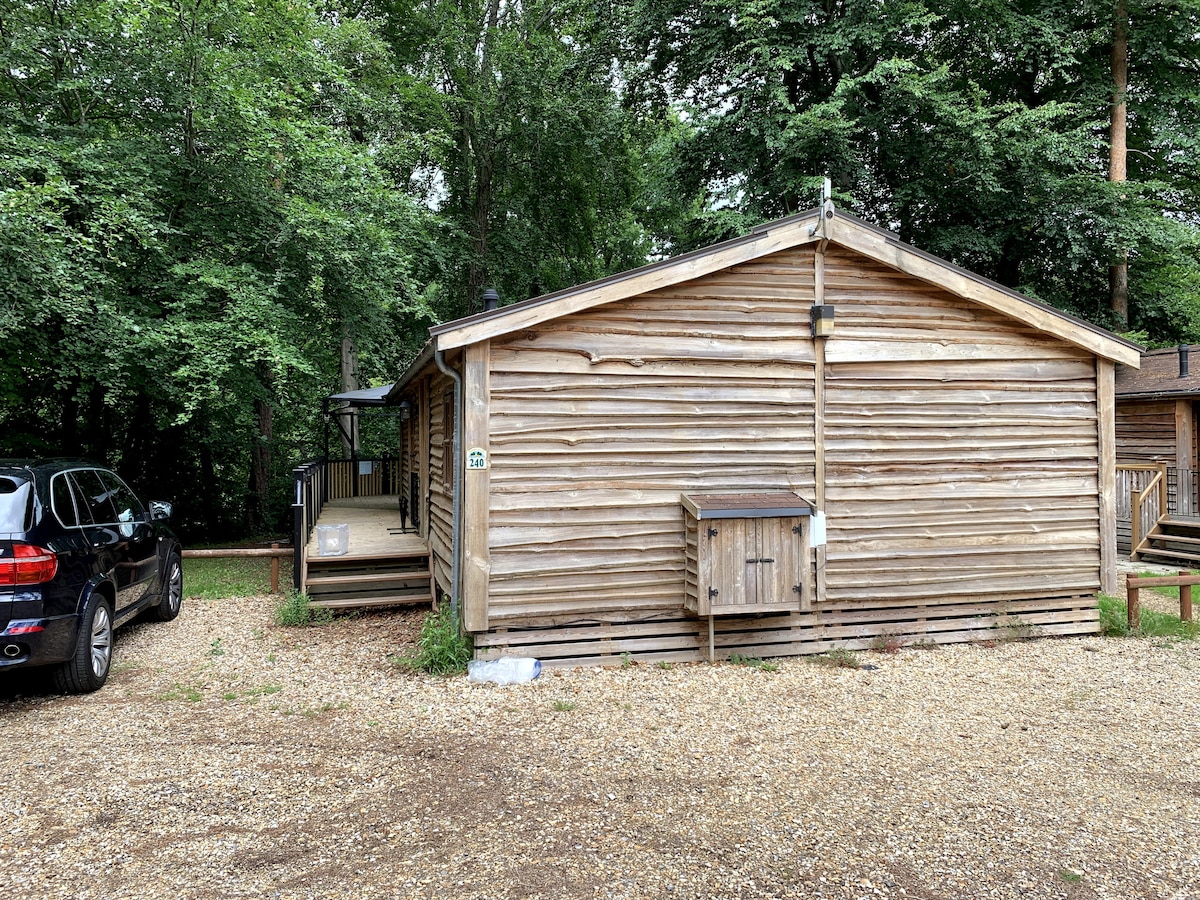 Log cabin exterior from the parking area with gravel drive and deck