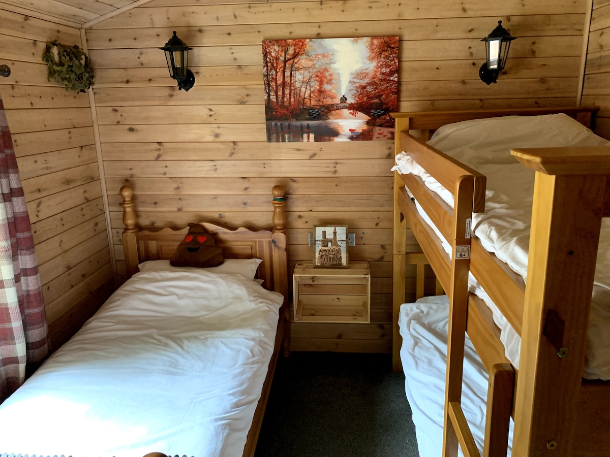 Children's bedroom with single bed, bunk beds and tartan curtains