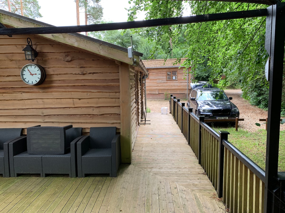 Long deck with rattan seating and boardwalk alongside the cabin