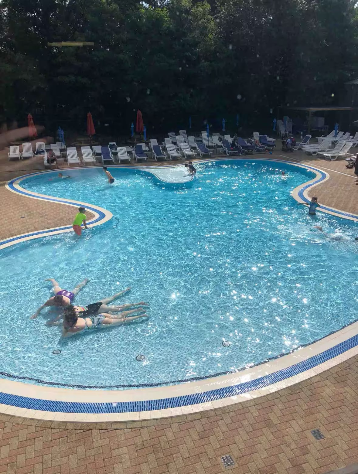 Outdoor swimming pool with sun loungers — shared leisure facility