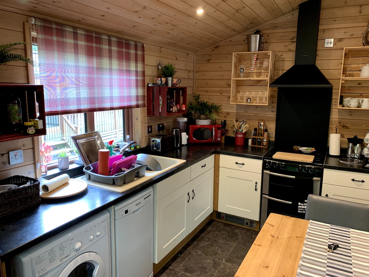 Kitchen with gas range, dishwasher, washing machine and tartan blind