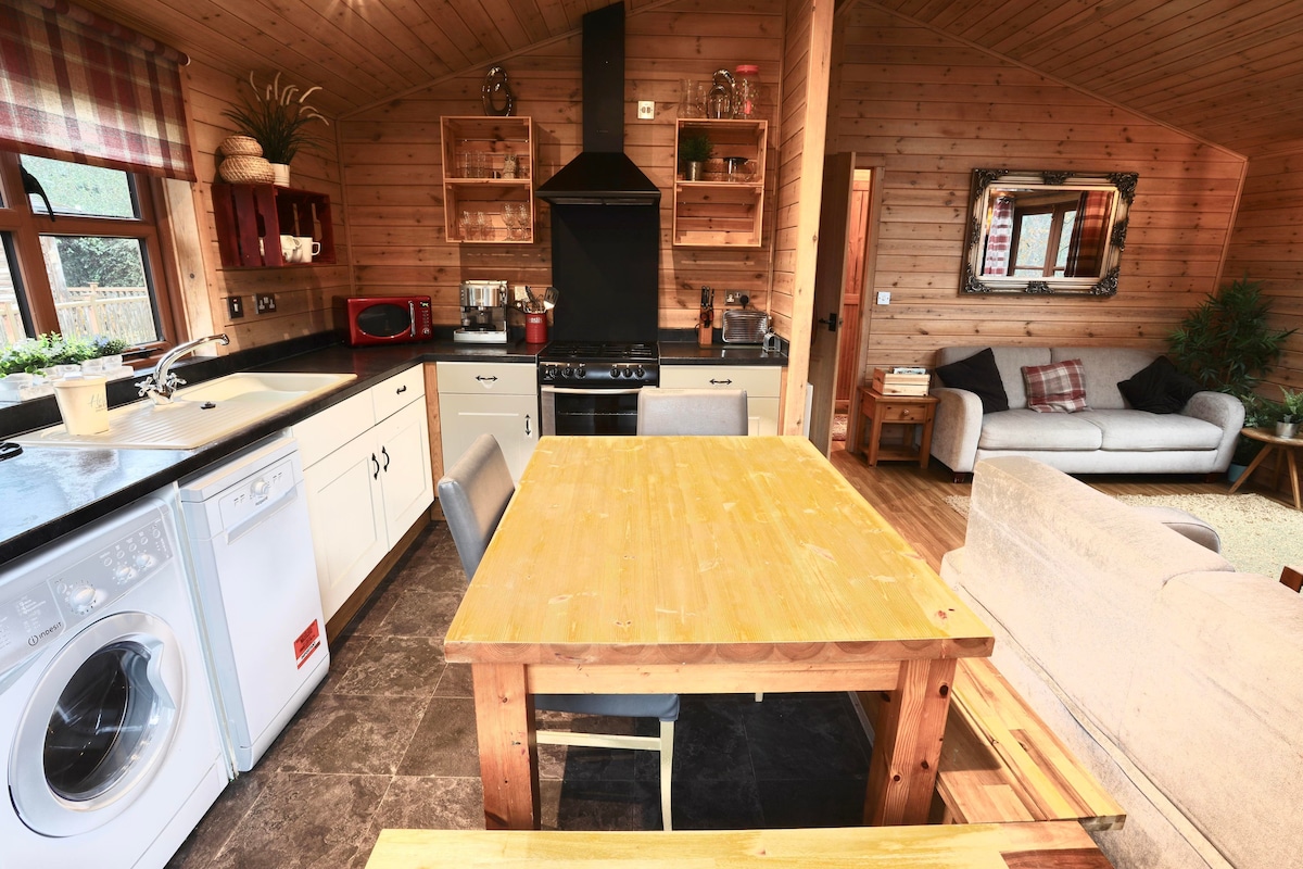 Open-plan kitchen with dining table, gas range and living room beyond